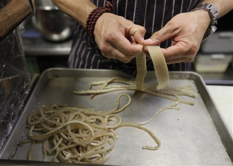 In this photo taken Monday, Aug. 15, 2011, chef Chris Cosentino separates cooked pork skin after running it through a spaghetti cutter to achieve proper size at the Incanto restaurant in San Francisco.  The skin was used to make pigskin spaghetti with clams and tomatoes. Pigskin is winning new appreciation as chefs tune in to its lush, unctuous properties.      (AP Photo/Eric Risberg)